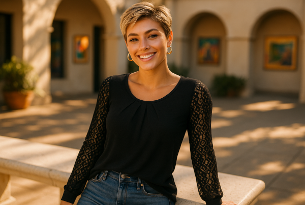 AI Model : On a sun-drenched art gallery courtyard, she leans casually against a white stone bench, pixie-cut blonde hair, wearing chunky gold hoop earrings.
